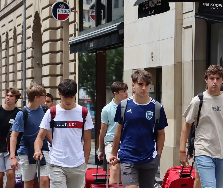 Schülerinnen und Schüler mit Koffern auf einer Berliner Straße bei der Ankunft.